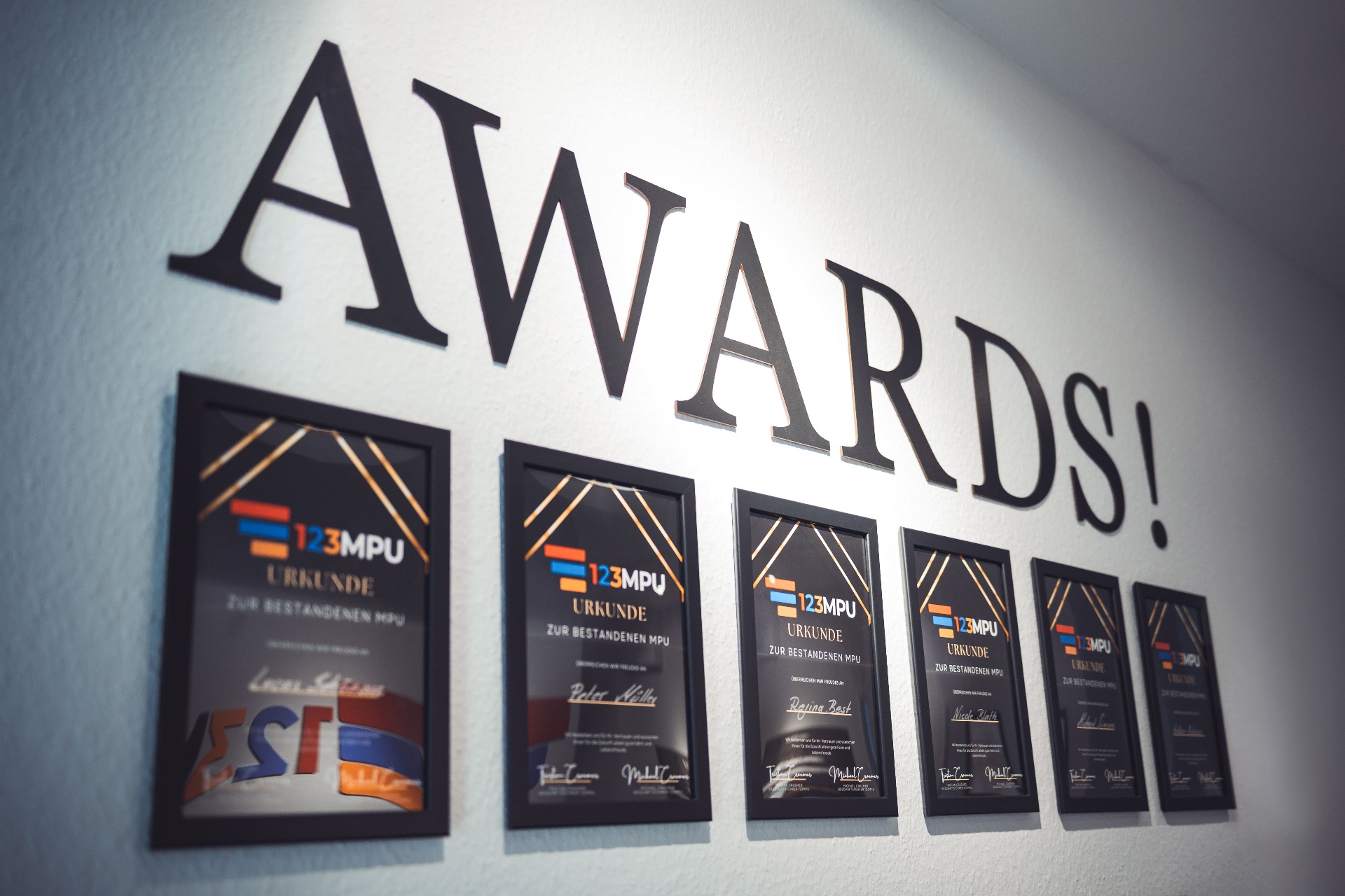 Awards-Wand bei 123MPU mit gerahmten Urkunden bestandener MPUs